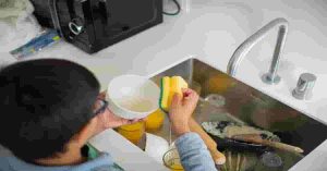 Hand washing utensils in kitchen